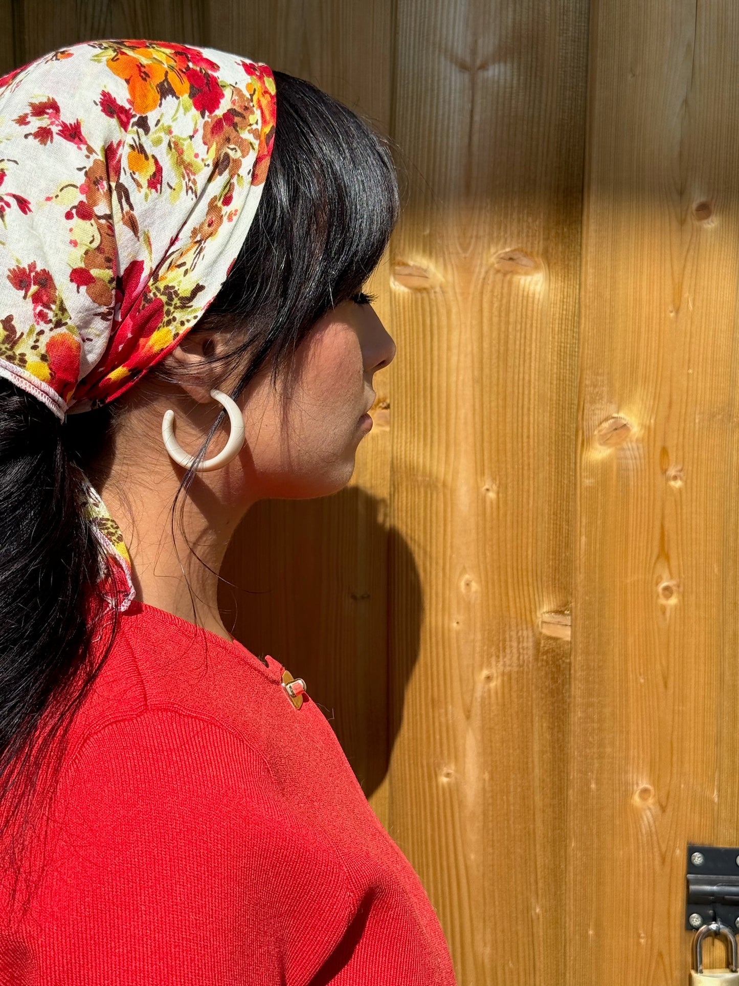 Jeune femme portant les boucles d'oreilles sabbia avec une tenue colorée, signé Onaïa Bijoux