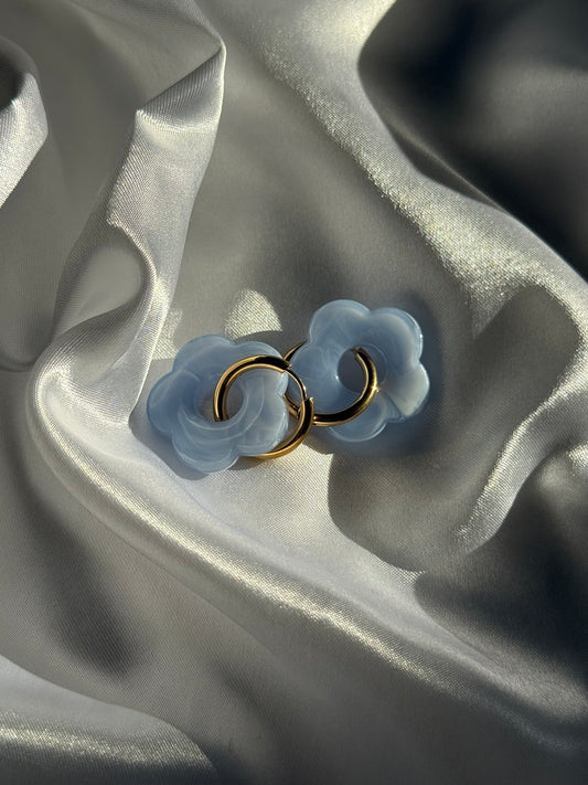 Boucles d'oreilles Flora en résine bleue et acier inoxydable doré sur fond blanc satiné - Onaïa Bijoux
