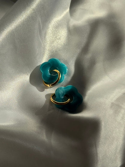 Boucles d'oreilles Flora en résine bleue et acier inoxydable doré sur fond blanc satiné - Onaïa Bijoux