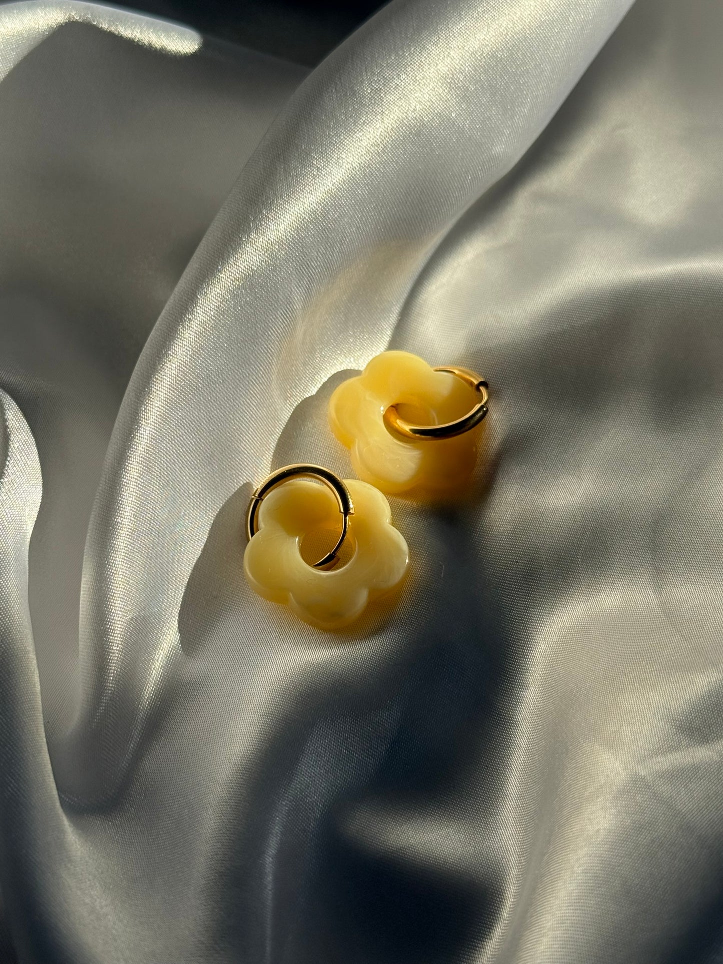 Boucles d'oreilles Flora en résine jaune et acier inoxydable doré sur fond blanc satiné - Onaïa Bijoux