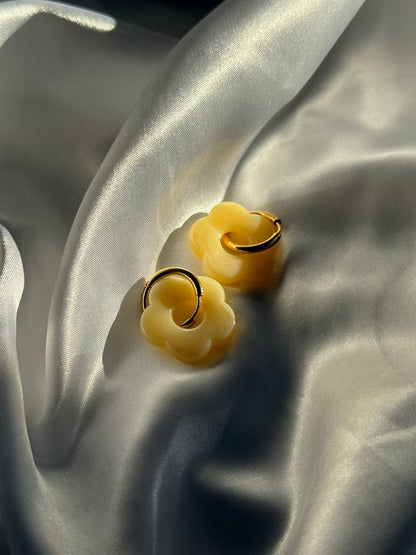 Boucles d'oreilles Flora en résine jaune et acier inoxydable doré sur fond blanc satiné - Onaïa Bijoux