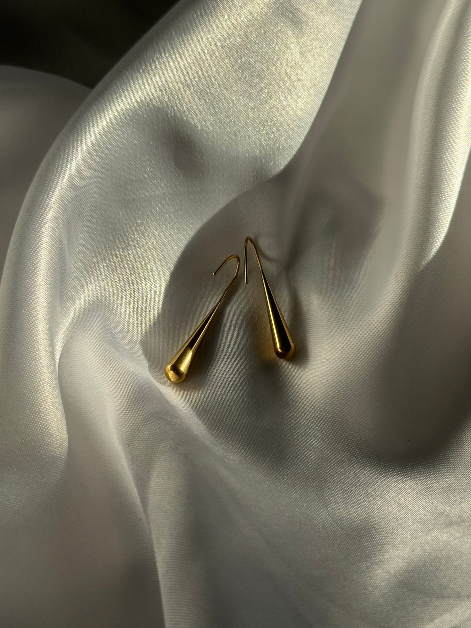 Boucles d'oreilles Lucea dorées en acier inoxydable sur fond blanc satiné - Onaïa Bijoux