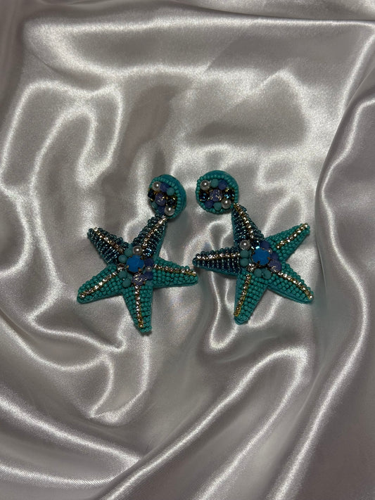 Boucles d'oreilles Sirena en perles bleues en forme d'étoile de mer sur fond blanc satiné - Onaïa Bijoux