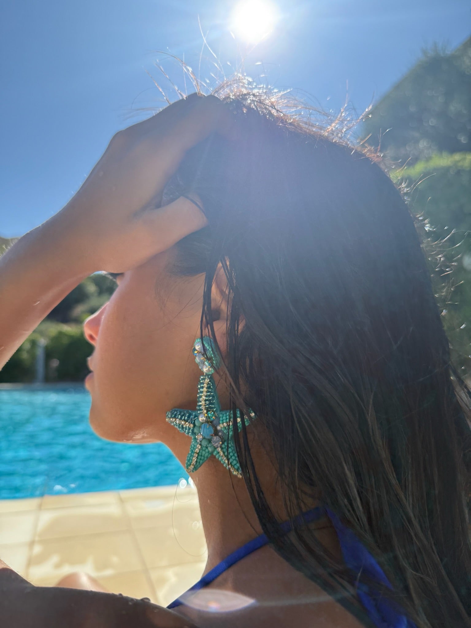 Boucles d'oreilles Sirena en perles portées pendant un bain de soleil à la piscine, signé Onaïa Bijoux
