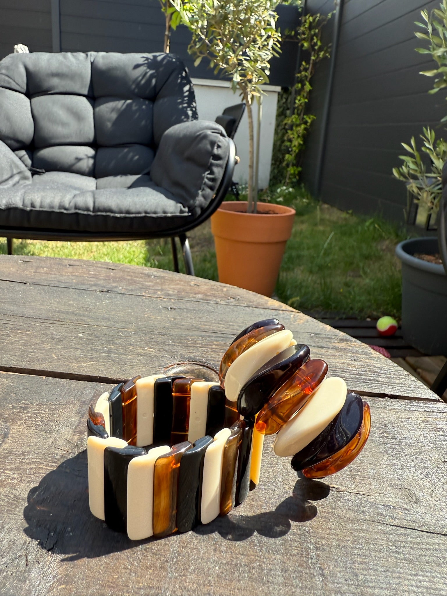 Bracelet Bruma en résine mis en scène dans le jardin en plein été avec son semblable, signé Onaïa bijoux