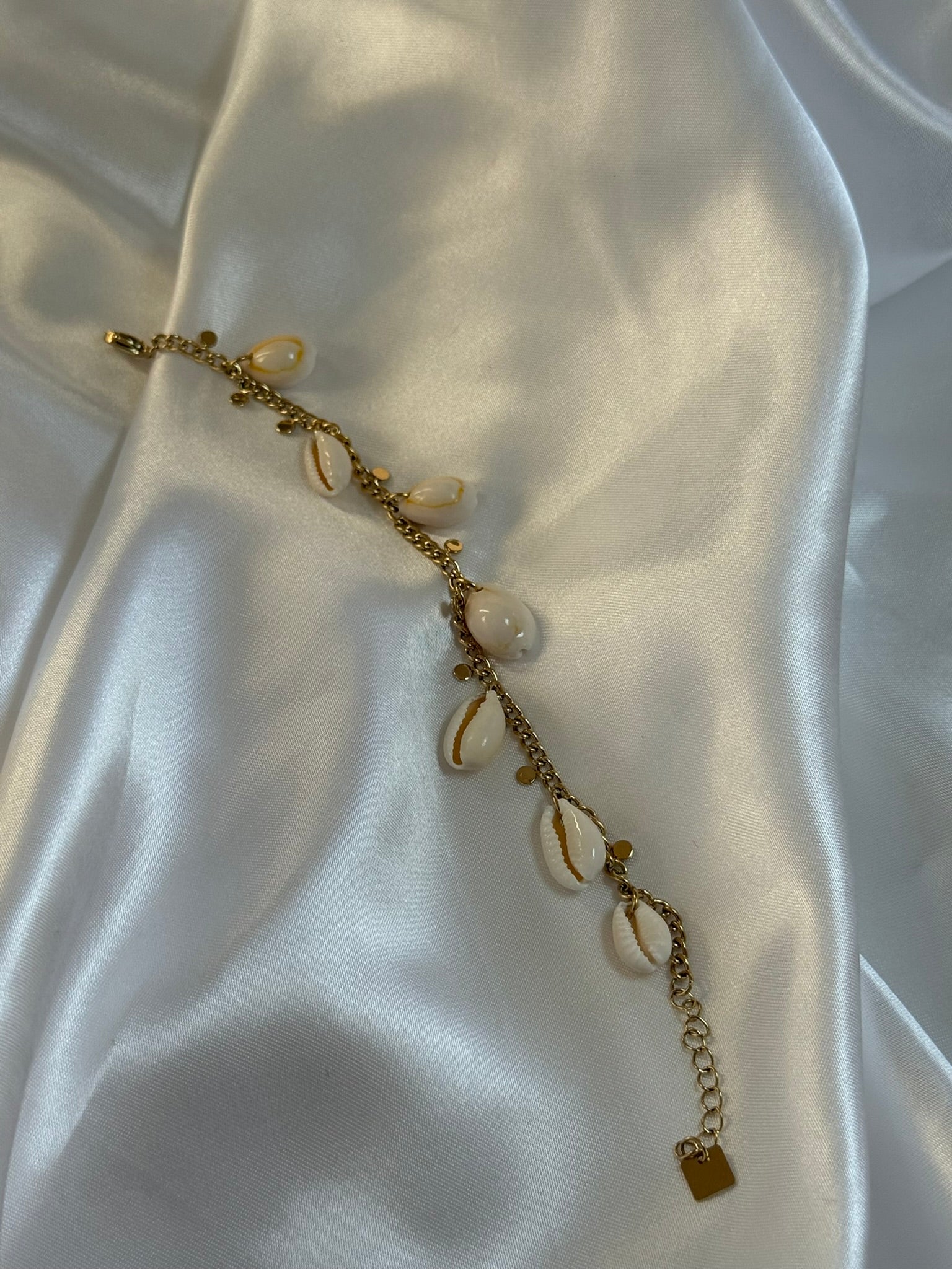 Bracelet Isla en acier inoxydable doré avec coquillages sur fond blanc - Onaïa Bijoux