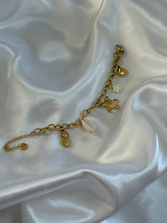Bracelet Isola en acier inoxydable doré avec des charms sur fond blanc satiné - Onaïa Bijoux