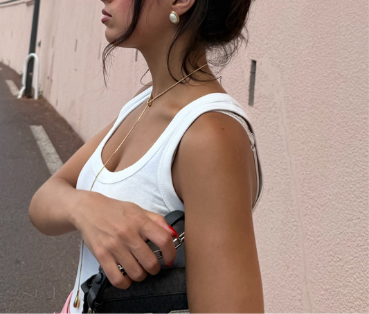 Collier Goccia en acier inoxydable doré porté sur la baie du cap d'Antibes, signé Onaïa Bijoux