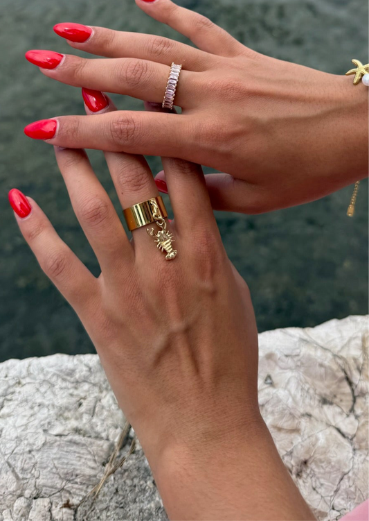 Bague dorée Lobsta signée Onaïa Bijoux portée à la main, ornée d’un petit homard pendant, pour un style ludique et affirmé.