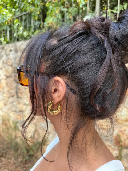 Boucles d'oreilles Luna Piena en acier inoxydable portées dans la baie du cap d'antibes avec un style retro, signé Onaïa Bijoux
