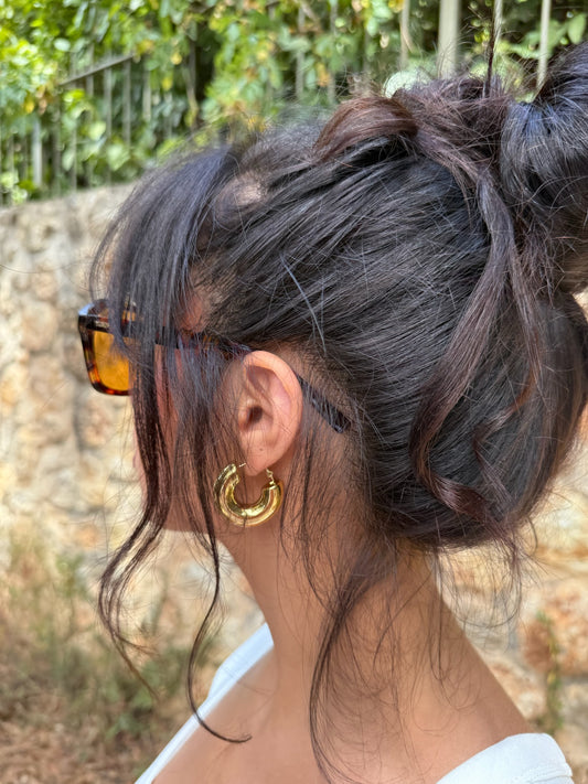 Boucles d'oreilles Luna Piena en acier inoxydable portées dans la baie du cap d'antibes avec un style retro, signé Onaïa Bijoux