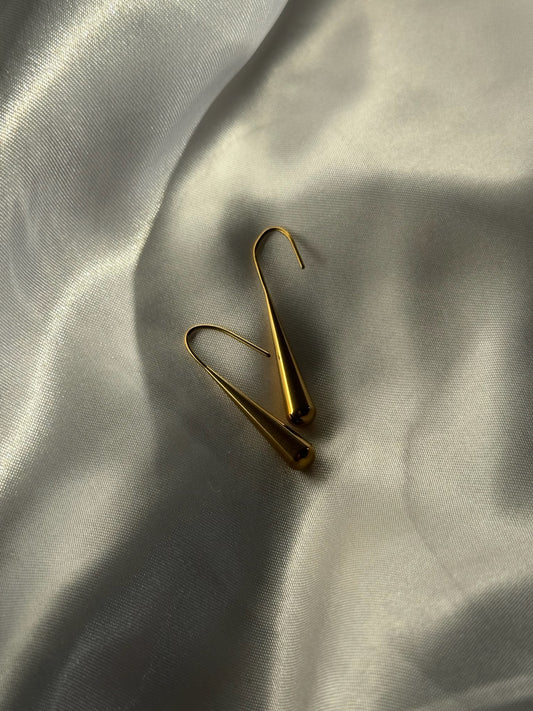 Boucles d’oreilles dorées Piovia en acier inoxydable, signées Onaïa Bijoux, inspirées des gouttes de pluie et posées sur satin blanc
