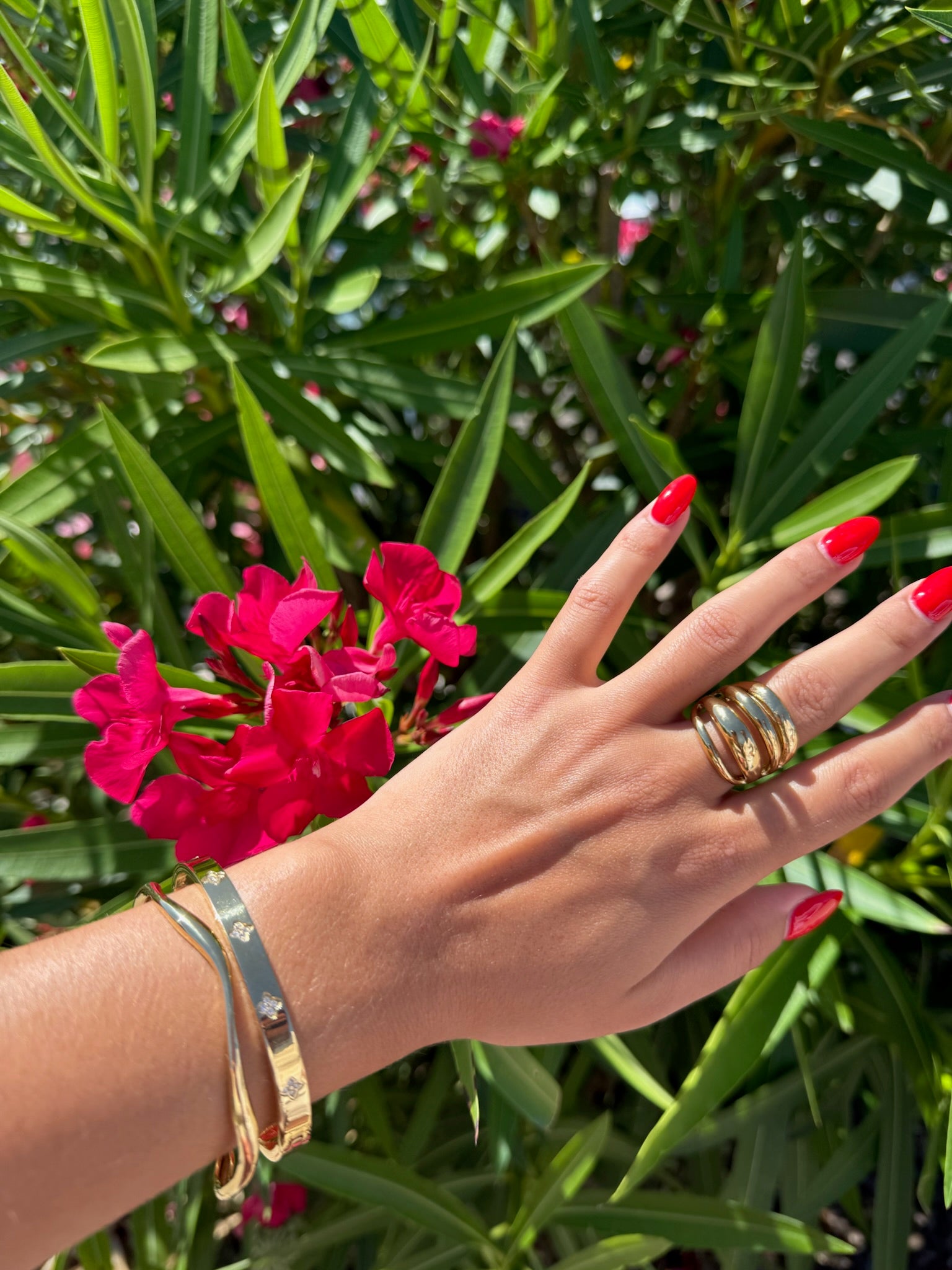 Bracelet doré Ondula en acier inoxydable, au design ondulé et minimaliste, porté avec élégance au poignet sous le soleil, création originale Onaïa Bijoux.