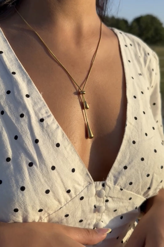 Jeune femme qui porte un collier en acier inoxydable dans un décor champêtre, Onaïa Bijoux