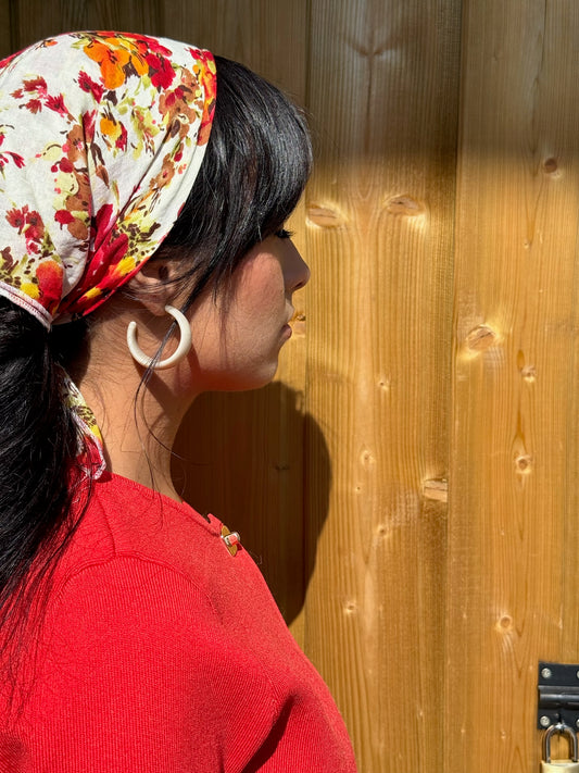 Jeune femme portant les boucles d'oreilles sabbia avec une tenue colorée, signé Onaïa Bijoux
